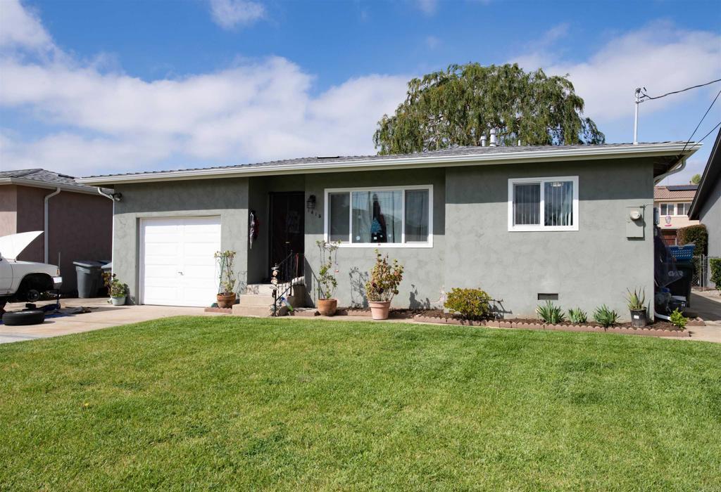 single story home featuring a front lawn and a garage