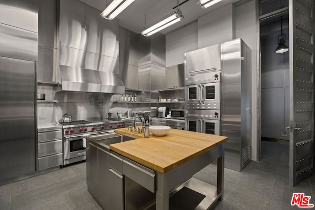 kitchen with sink, a kitchen island, backsplash, and premium appliances