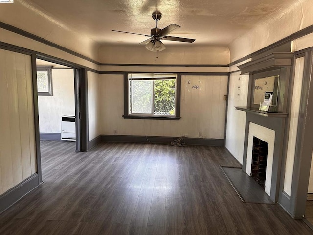 unfurnished living room featuring ceiling fan and dark hardwood / wood-style flooring