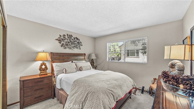 bedroom featuring light colored carpet and a textured ceiling