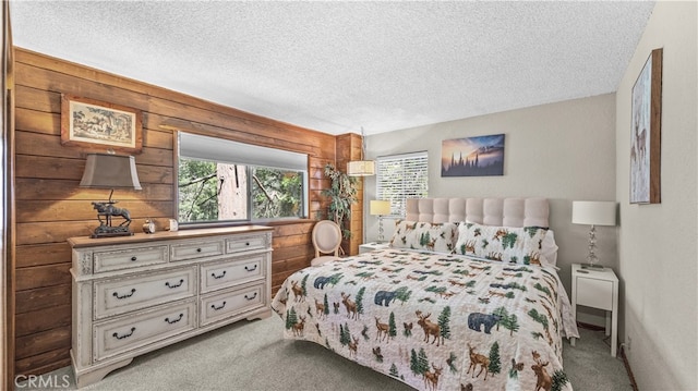 carpeted bedroom featuring a textured ceiling and wooden walls