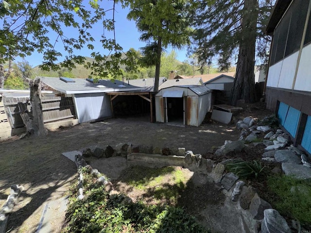 rear view of property featuring a storage unit