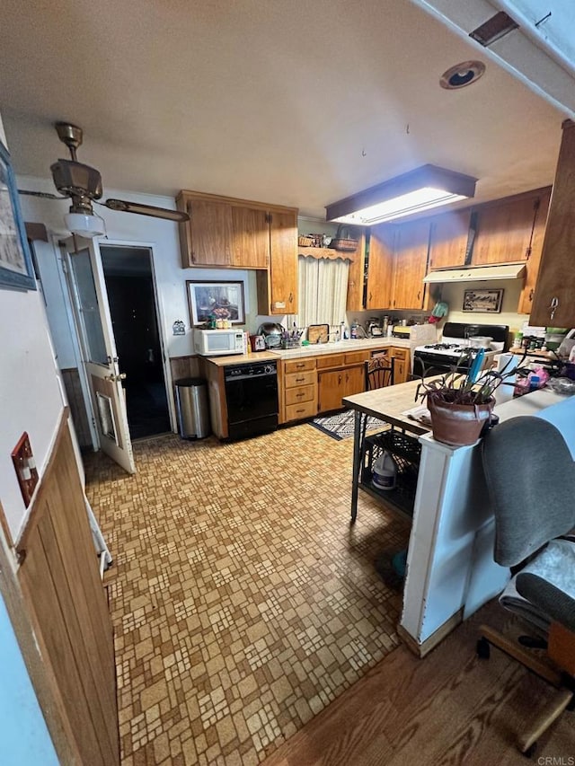 kitchen featuring hardwood / wood-style floors, ceiling fan, white appliances, and kitchen peninsula