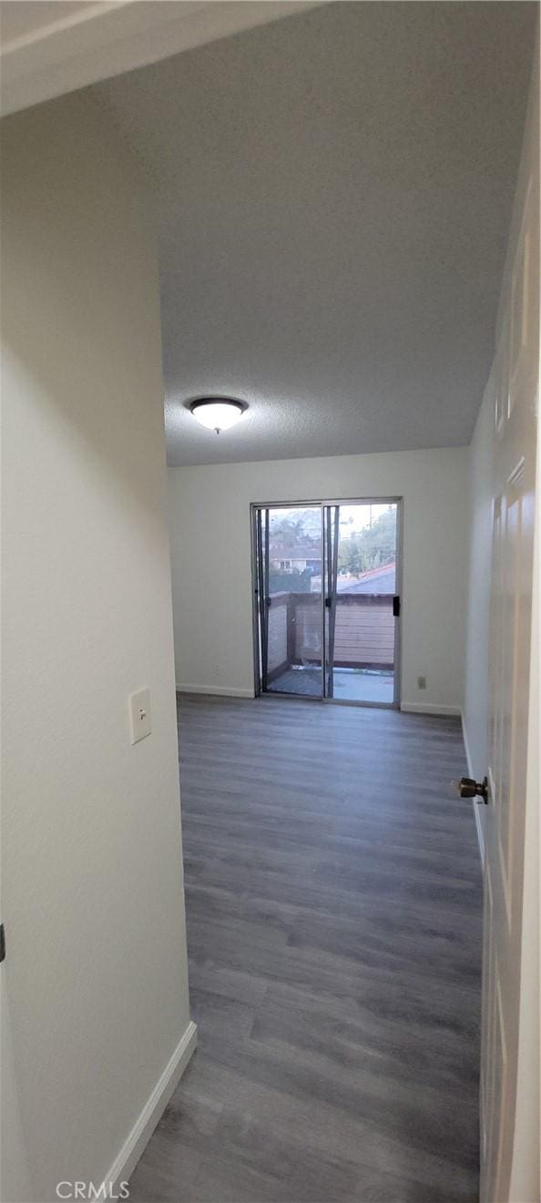 unfurnished room with dark hardwood / wood-style flooring and lofted ceiling