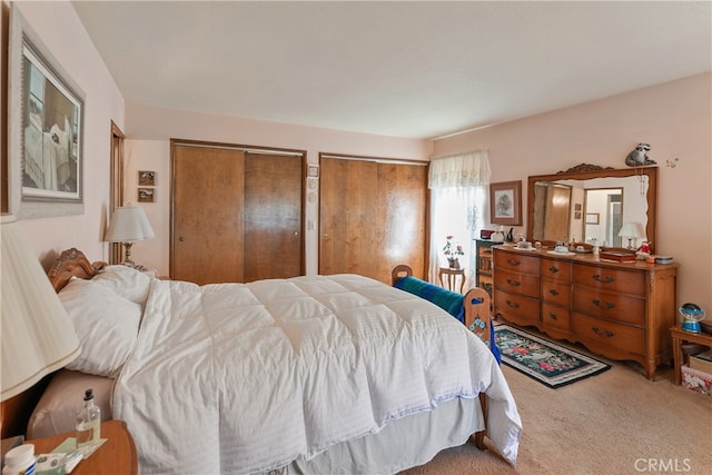 carpeted bedroom featuring multiple closets