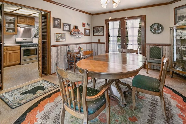 dining space featuring french doors, light colored carpet, and ornamental molding