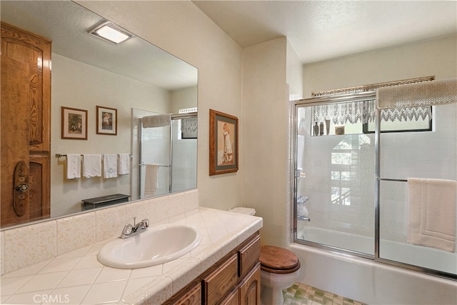 full bathroom with vanity, toilet, and bath / shower combo with glass door