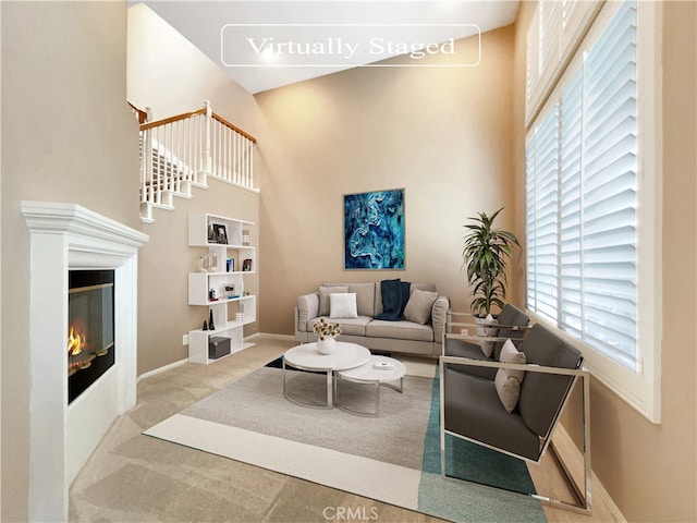 living room featuring carpet flooring and a high ceiling