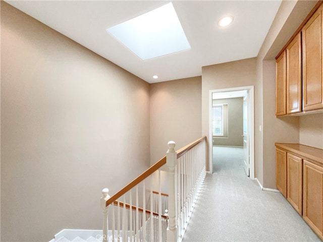 hall featuring light carpet and a skylight