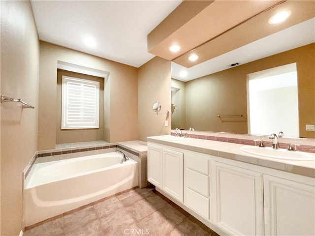 bathroom with vanity, a bathtub, and tile patterned flooring