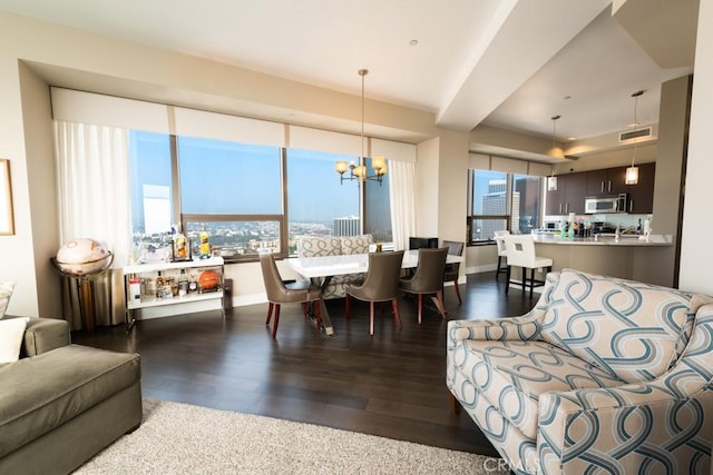 living area featuring wood finished floors, visible vents, baseboards, and an inviting chandelier