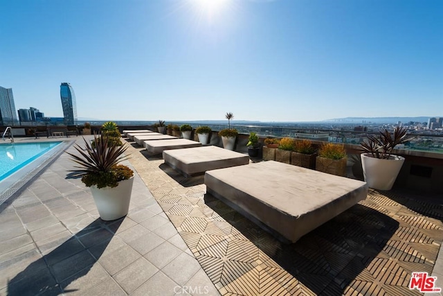 view of patio / terrace with a community pool and a view of city