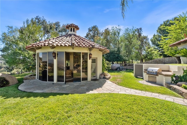 exterior space with an outdoor kitchen and a yard