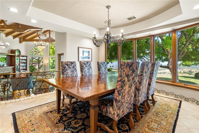 dining space with a raised ceiling, beamed ceiling, and a chandelier