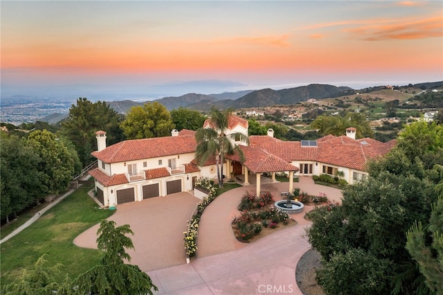 aerial view at dusk featuring a mountain view