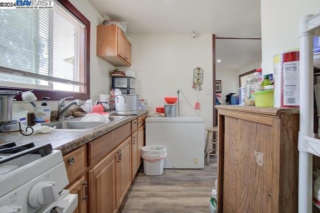 kitchen with sink, white range oven, and light wood-type flooring