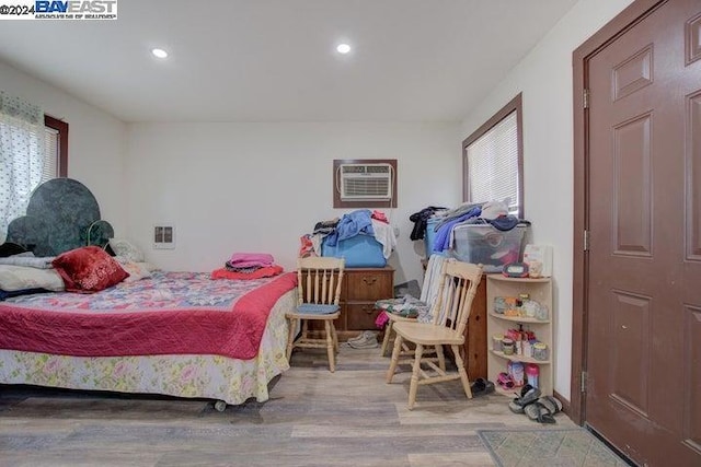 bedroom featuring a wall unit AC and hardwood / wood-style flooring