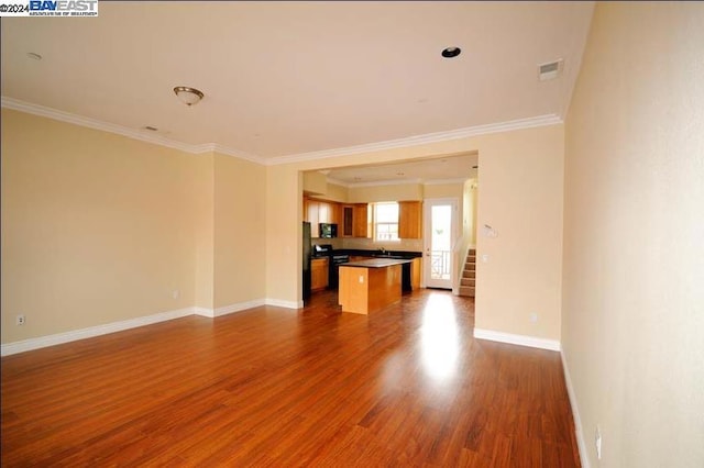 unfurnished living room featuring ornamental molding, dark wood-type flooring, and sink