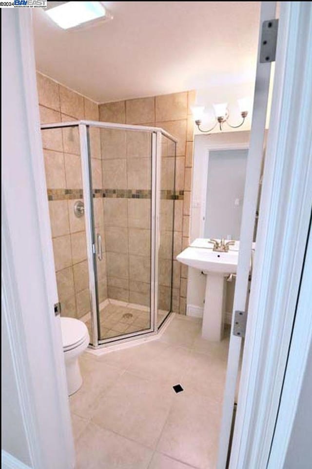 bathroom with toilet, tile patterned floors, and a shower with shower door