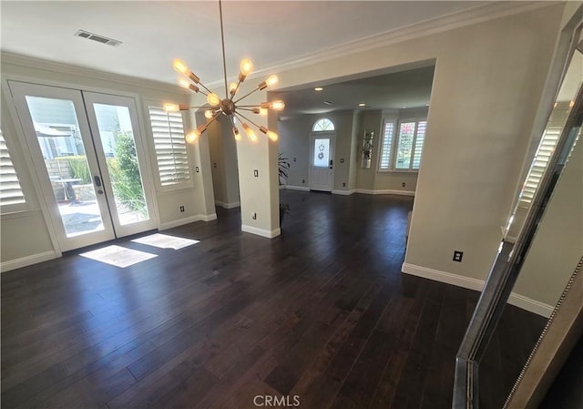 unfurnished dining area featuring crown molding, dark hardwood / wood-style flooring, french doors, and a notable chandelier