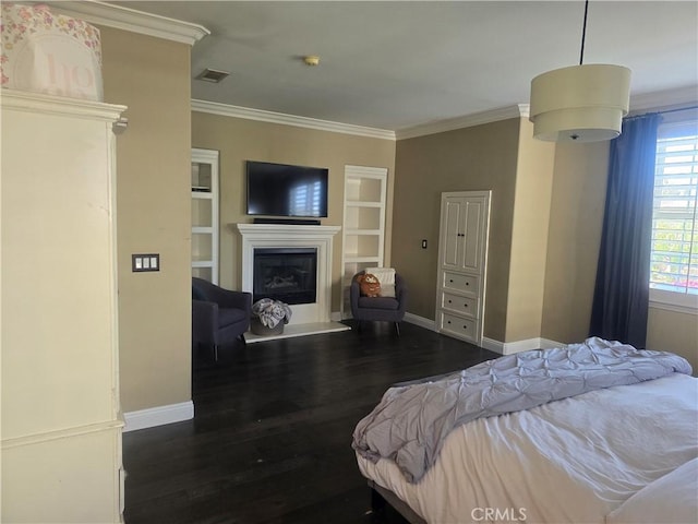 bedroom with dark wood-style floors, visible vents, ornamental molding, a glass covered fireplace, and baseboards