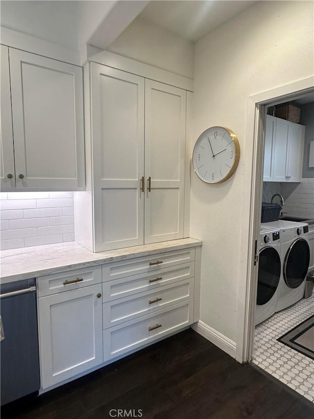 interior space with washing machine and dryer, cabinets, sink, and dark wood-type flooring