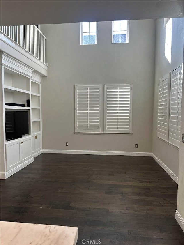 unfurnished living room with dark wood-type flooring