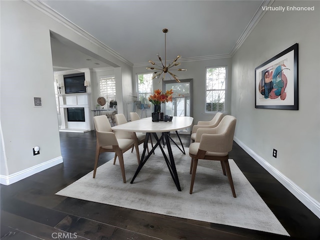 dining area with ornamental molding, dark wood-type flooring, a wealth of natural light, and a glass covered fireplace