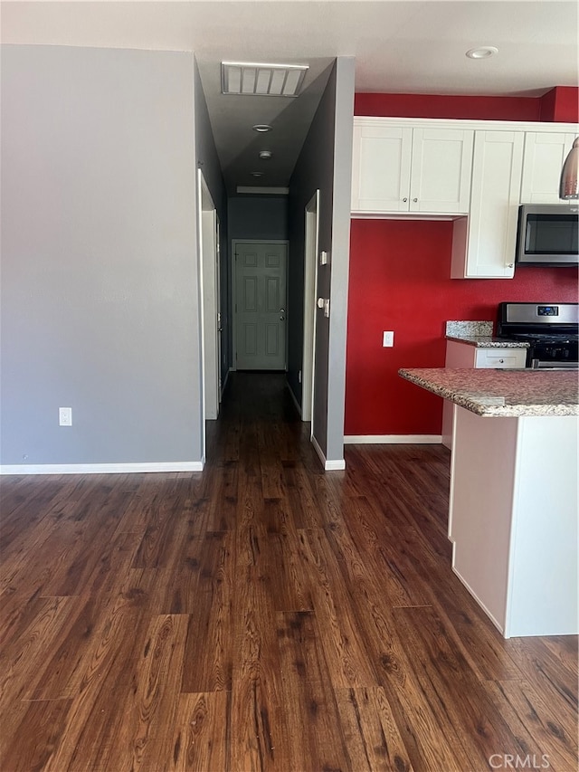 kitchen featuring dark wood-type flooring, appliances with stainless steel finishes, and white cabinets