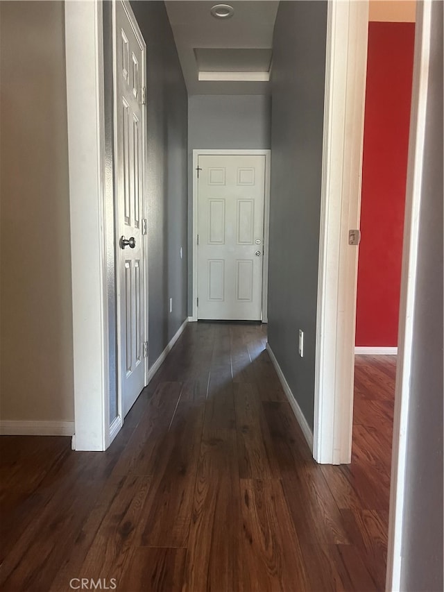 corridor with dark hardwood / wood-style flooring