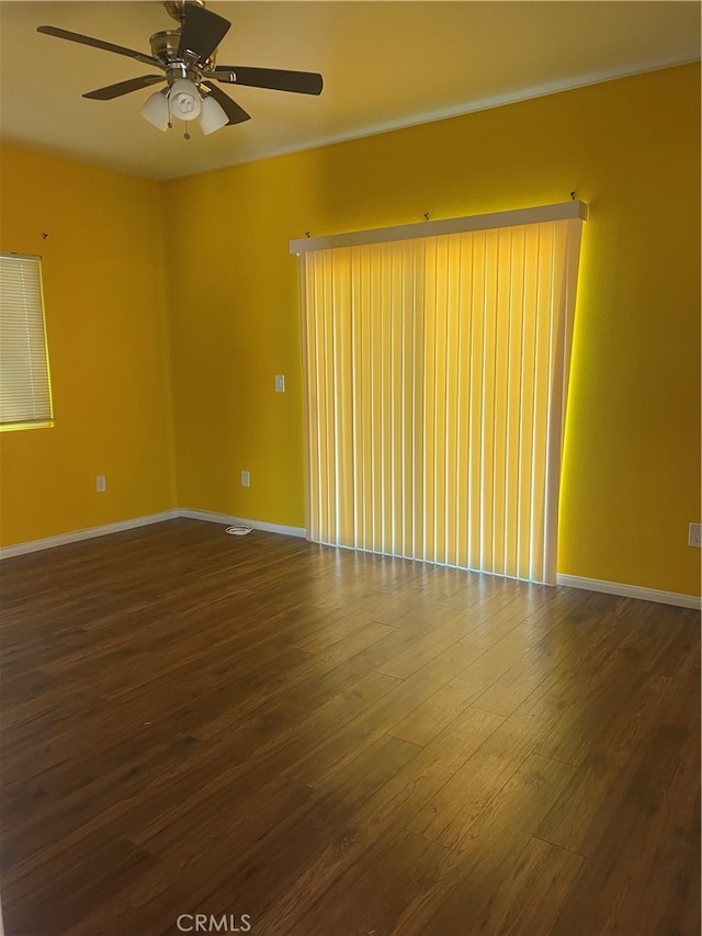 empty room with dark hardwood / wood-style floors and ceiling fan