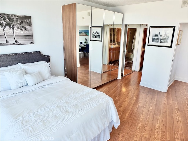 bedroom with light hardwood / wood-style floors and connected bathroom