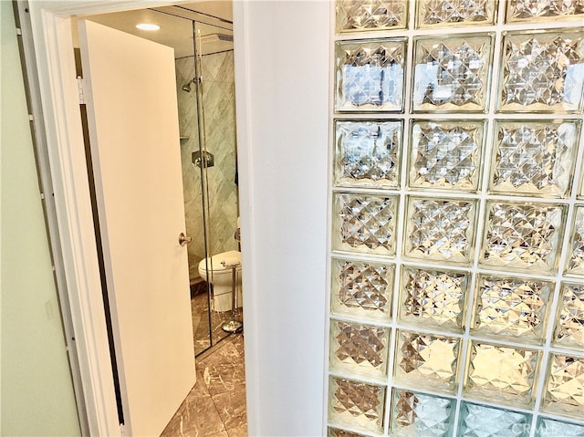 bathroom featuring toilet and tiled shower