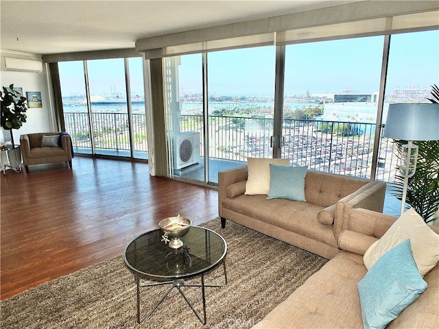 living room with a wall of windows, an AC wall unit, wood-type flooring, and a water view