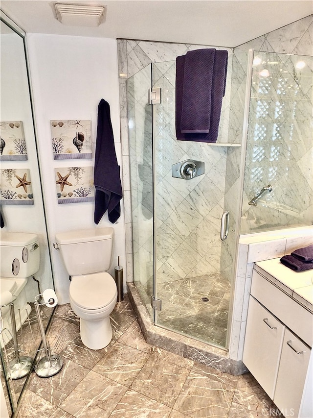 bathroom featuring vanity, toilet, and walk in shower