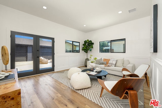 living room featuring light hardwood / wood-style floors, a wealth of natural light, and french doors