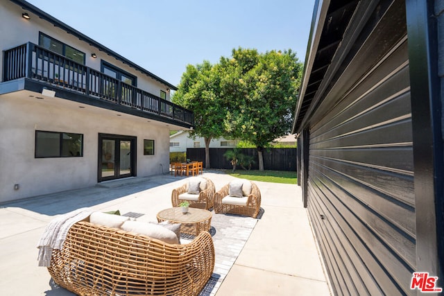 view of patio / terrace featuring an outdoor living space, a balcony, and french doors