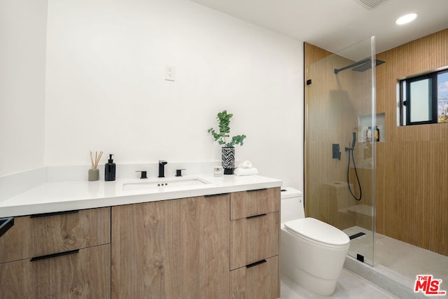 bathroom with tile patterned flooring, vanity, toilet, and tiled shower