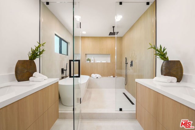 bathroom with tile patterned floors, vanity, and shower with separate bathtub