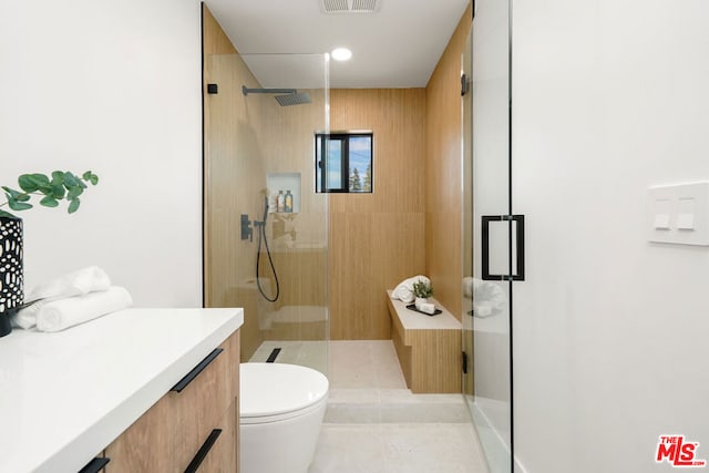 bathroom with tile patterned floors, a shower with shower door, and toilet