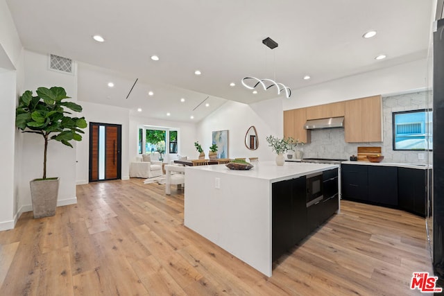 kitchen with pendant lighting, a center island, light hardwood / wood-style floors, and light brown cabinets