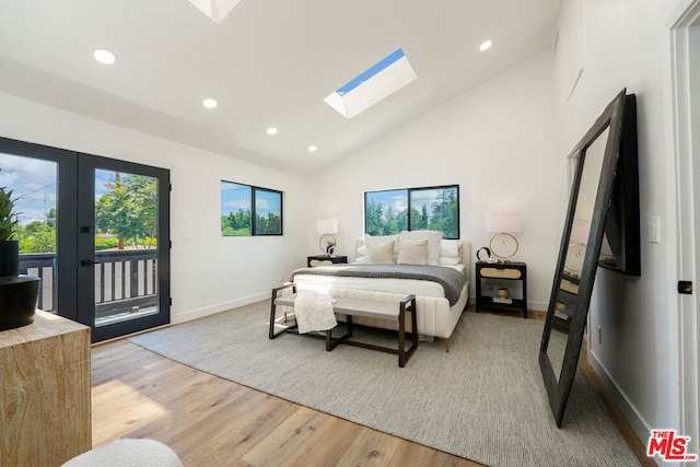 bedroom with french doors, light wood-type flooring, a skylight, access to outside, and high vaulted ceiling