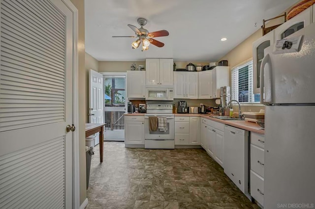 kitchen featuring white appliances, ceiling fan, sink, and white cabinets