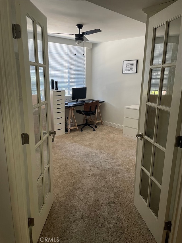 carpeted home office with french doors and ceiling fan