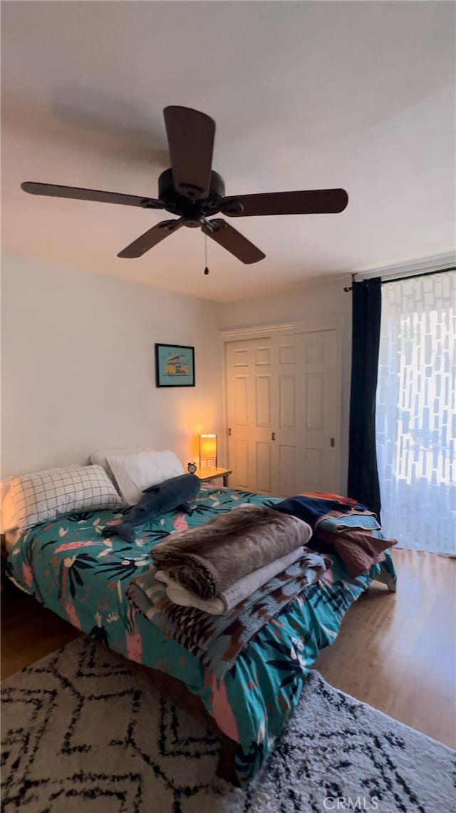 bedroom with a closet, ceiling fan, and hardwood / wood-style floors