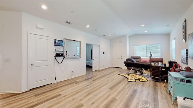 interior space with light wood-type flooring and vaulted ceiling