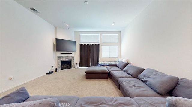 carpeted living room featuring a stone fireplace