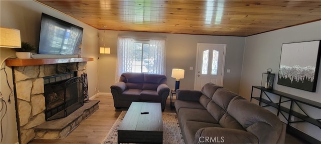 living room with wood ceiling, a stone fireplace, and light hardwood / wood-style flooring