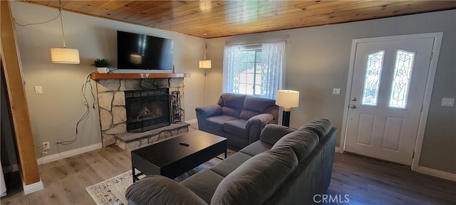 living room featuring a stone fireplace, wood ceiling, and wood-type flooring