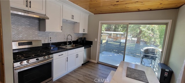 kitchen featuring appliances with stainless steel finishes, decorative backsplash, white cabinets, and sink